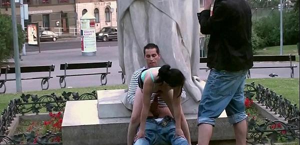  A young cute girl with 2 friends public street sex threesome gangbang by a world famous statue at the central square fucking her tiny wet pussy in turn and shove their big hard cocks in her deep throat oral sexual risky adventure action
